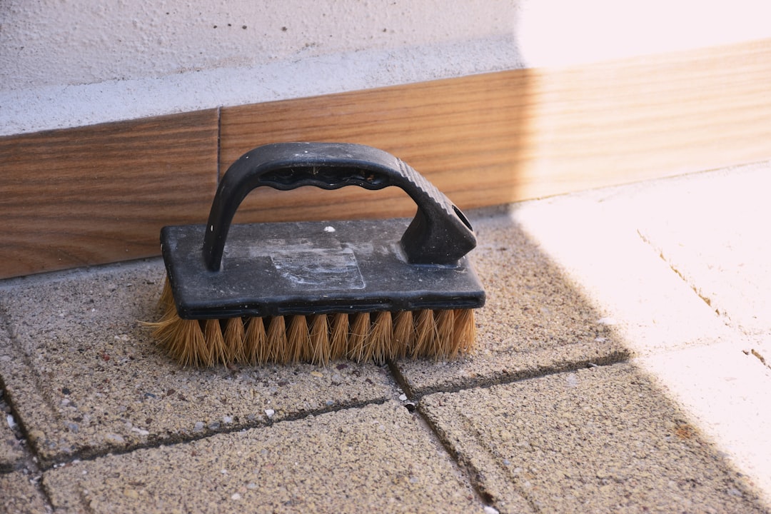 a-black-handled-scrubbing-brush-on-paving-stones-4v0mqrgdzvi